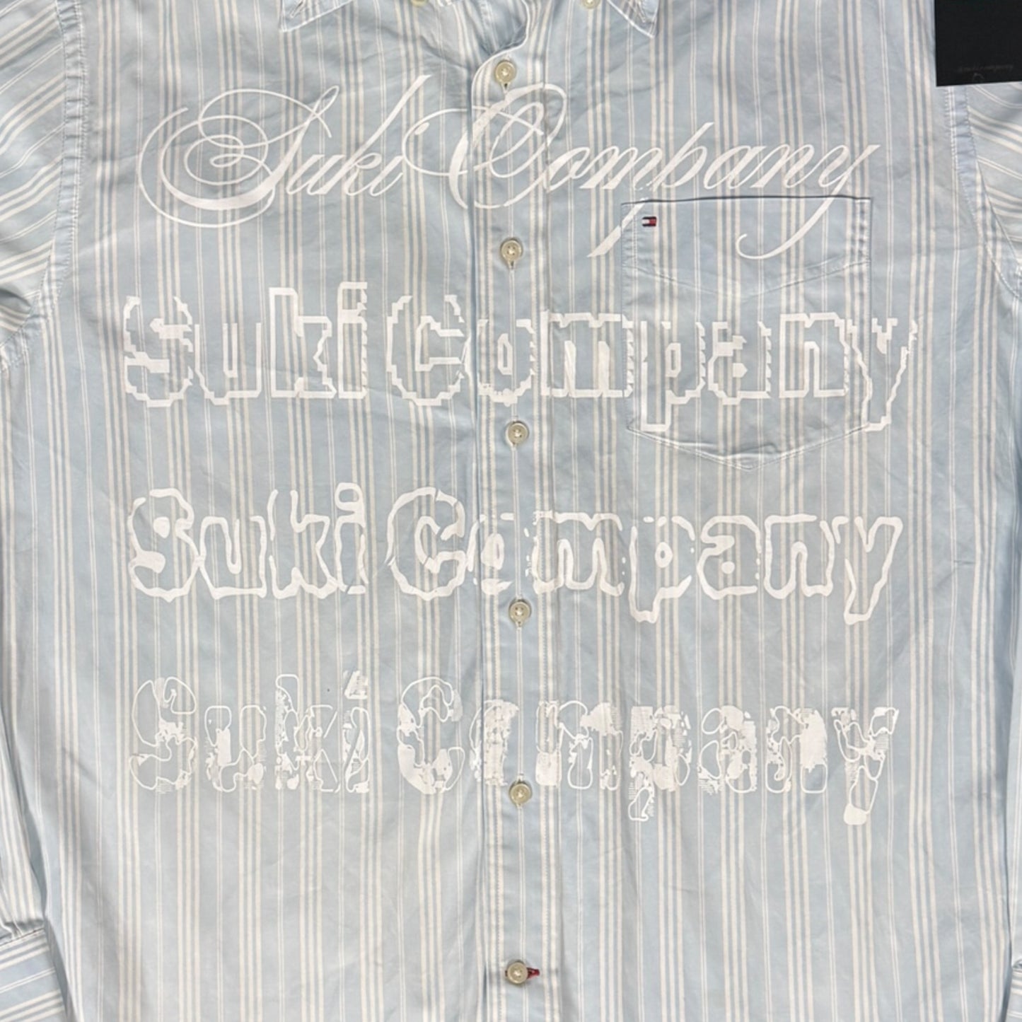CAMISA MANGA LARGA SUKI AZUL CLARO RAYAS LETRAS BLANCAS TALLA L SK206