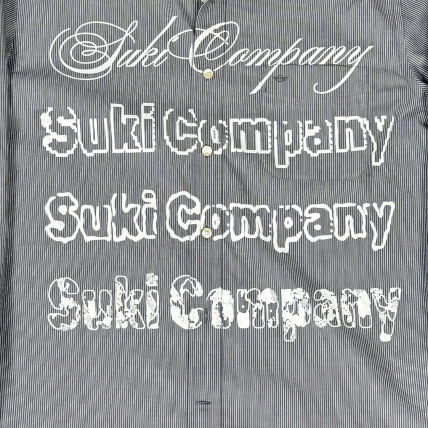 CAMISA MANGA LARGA SUKI GRIS RAYAS LETRAS BLANCAS TALLA L SK210